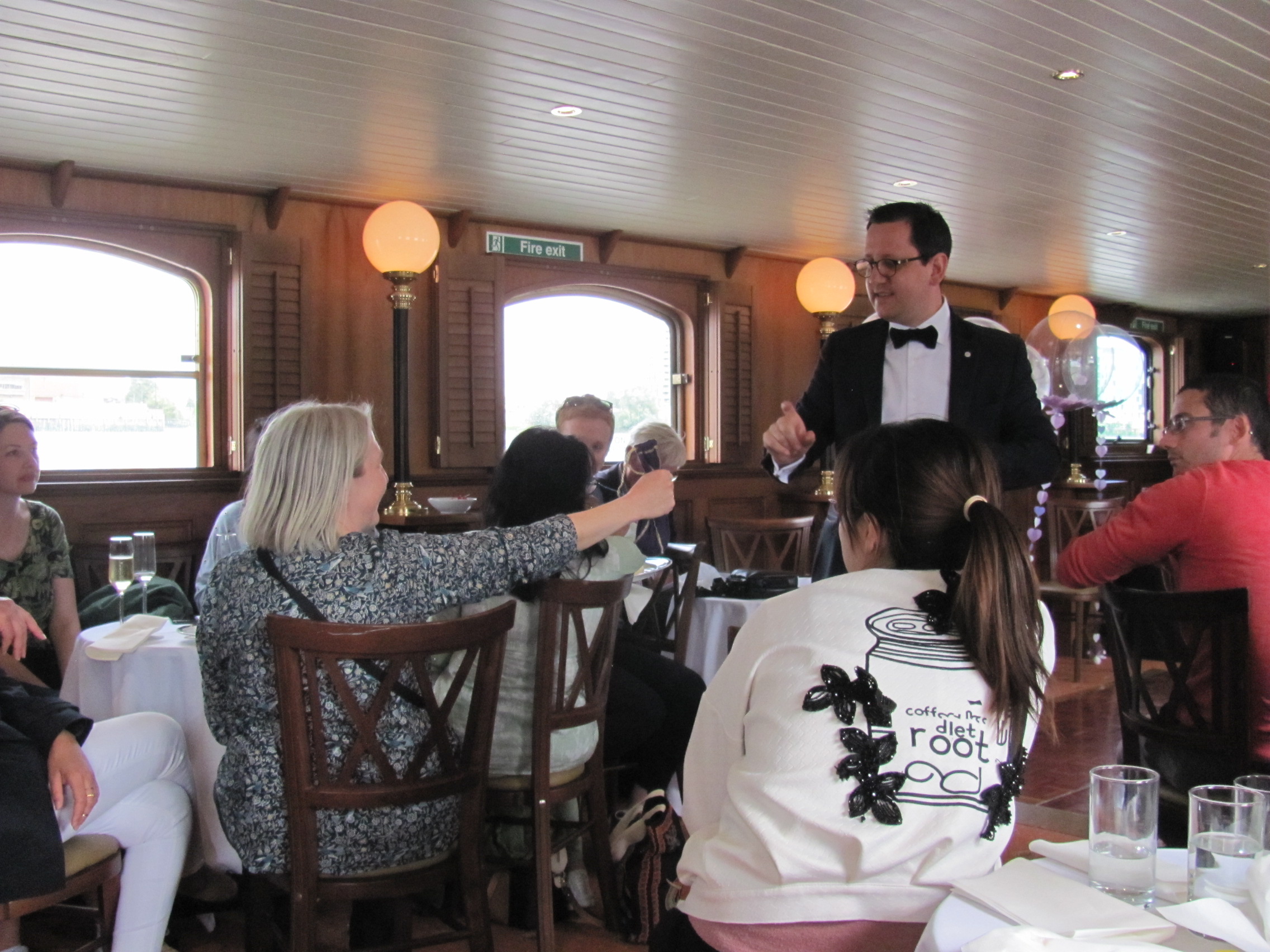 Image 1 shows people playing foosball. Image 2 shows people with rifles on a boat. Image 3 shows people on a boat. Image 4 shows people gathered around dining tables on a boat.
