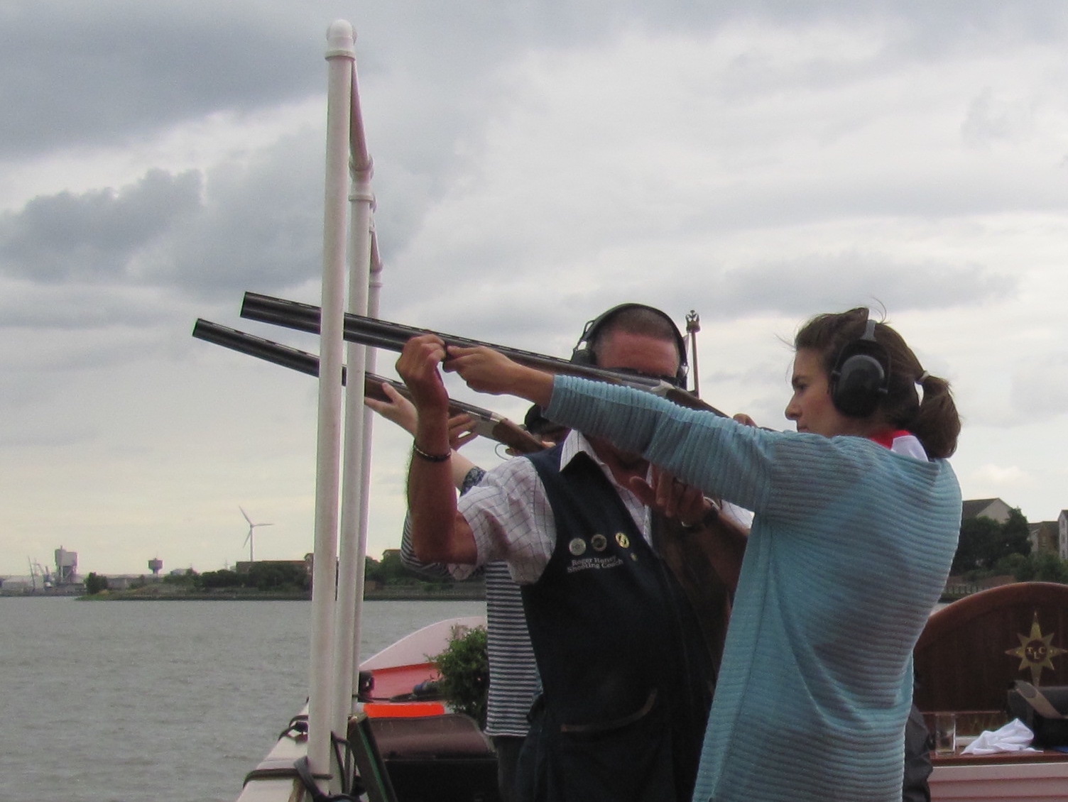Image 1 shows people playing foosball. Image 2 shows people with rifles on a boat. Image 3 shows people on a boat. Image 4 shows people gathered around dining tables on a boat.