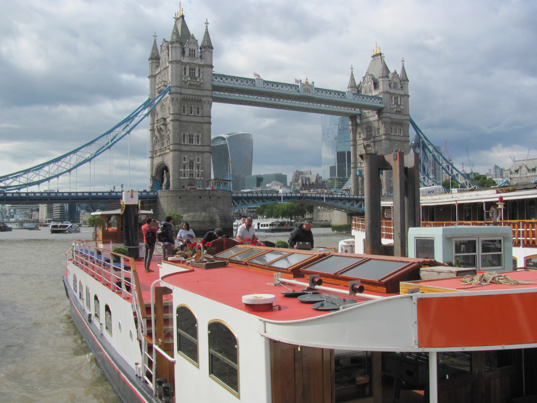 Image 1 shows people playing foosball. Image 2 shows people with rifles on a boat. Image 3 shows people on a boat. Image 4 shows people gathered around dining tables on a boat.